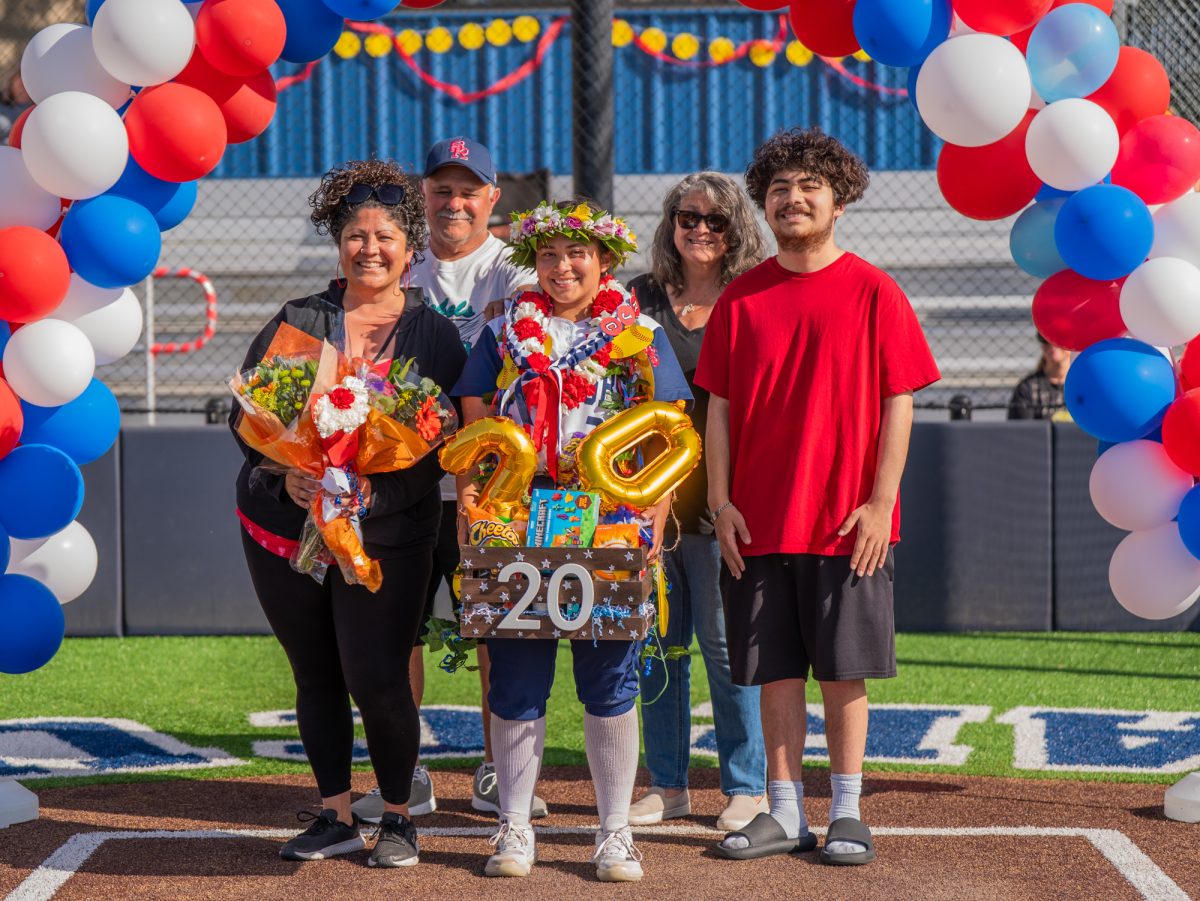 Sophomore third baseman Gabby Schenone, center, stands at home plate with her family while her athletic accolades are announced overhead on Sophomore Day on Tuesday, April 22 at home.