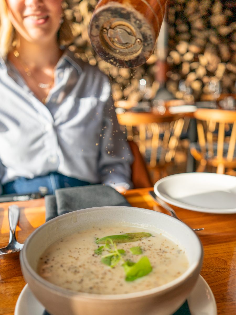 Fresh black pepper is cracked tableside over the smoked trout chowder at Coast Kitchen on March 18, 2025 in Jenner, California.