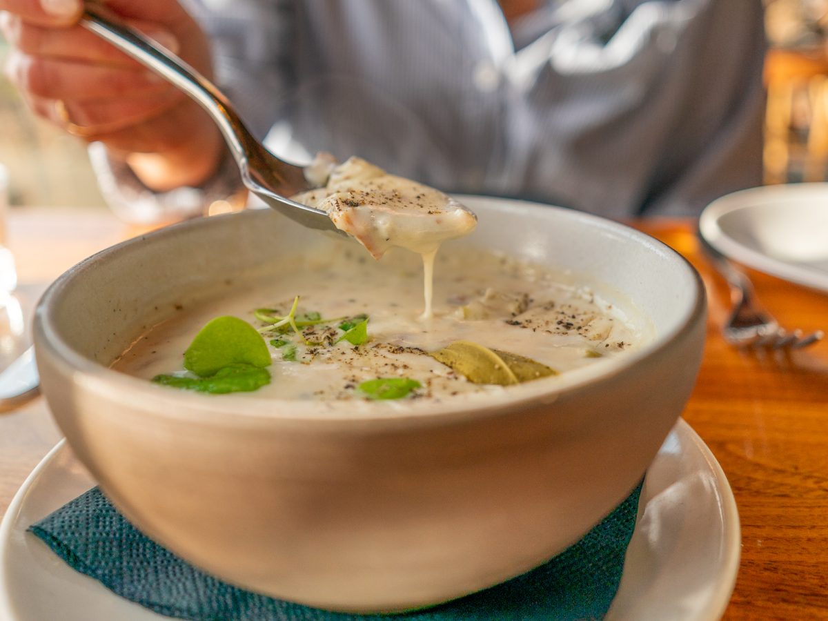 A bowl of smoked trout chowder features potato, fennel, clams, cream, microgreens and topped with fresh cracked black pepper at Coast Kitchen on March 18, 2025 in Jenner, California.