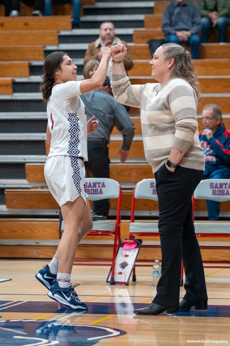 Santa Rosa Junior College's sophomore guard, Lindsey Arellano does a personalized handshake with head-coach Lacey Campbell as Arellano's name rings around Haehl Pavilion prior to the match up against Sierra College on Jan. 11, 2025. 