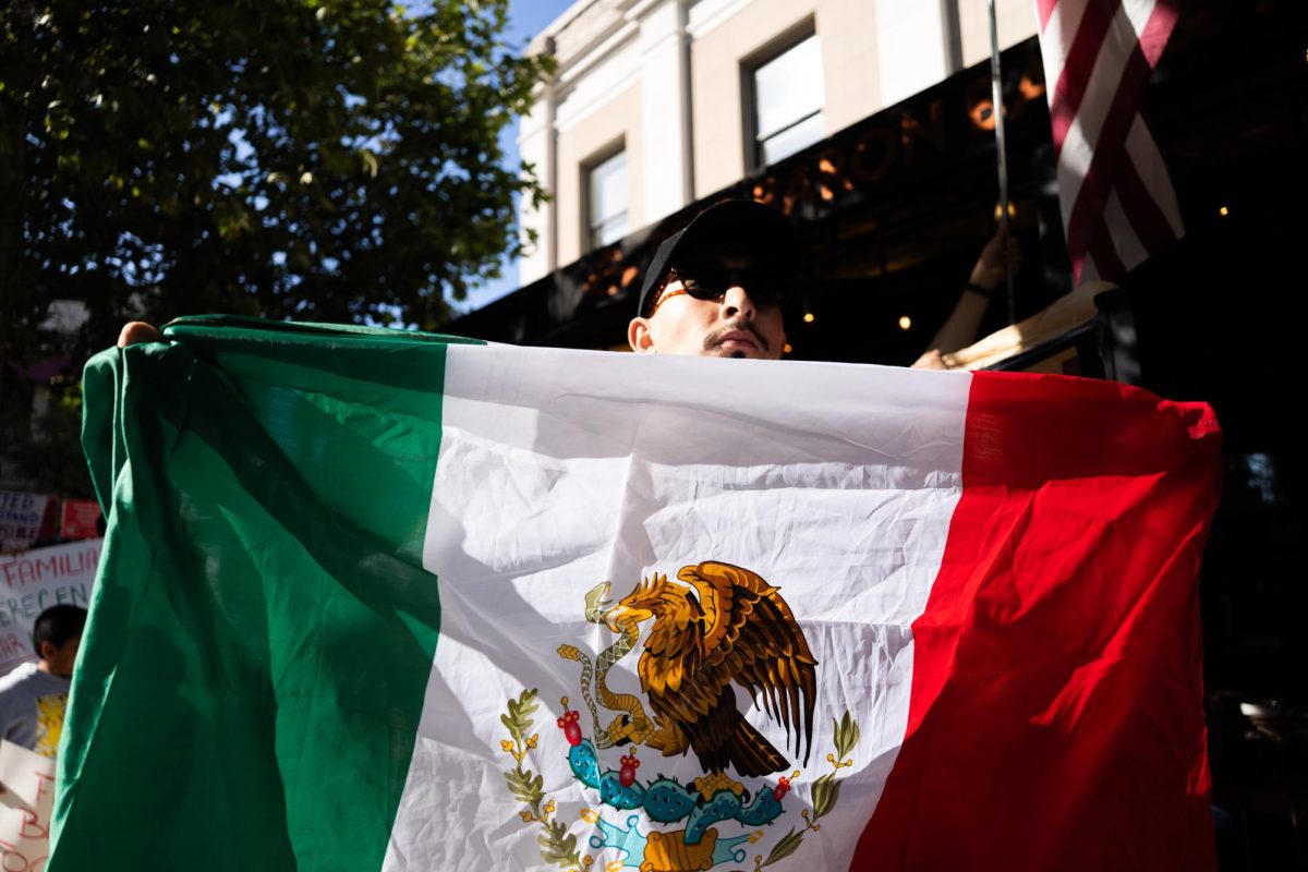 A protestor waves around a Mexican flag during a protest in downtown Santa Rosa on Wednesday, June 11, 2025.