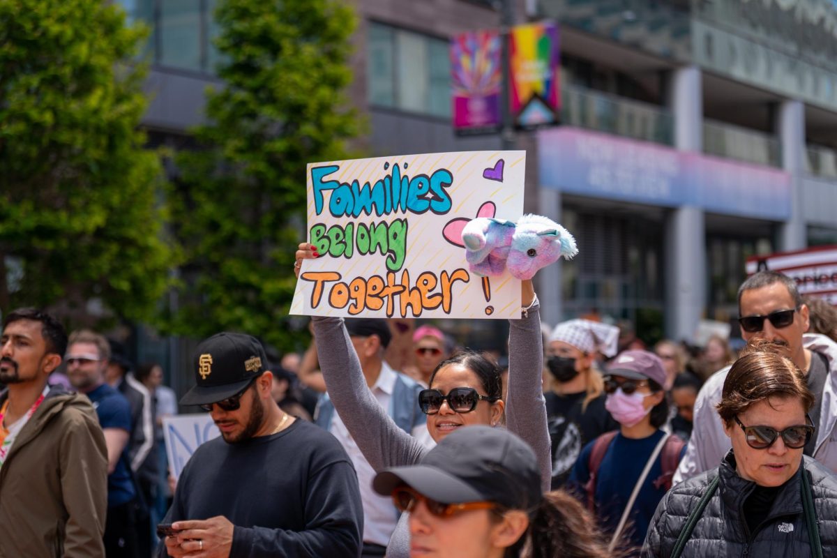 Protesters at the Civic Center Plaza hold up signs during "No Kings Day" on Saturday, June 14, 2025 in San Francisco.