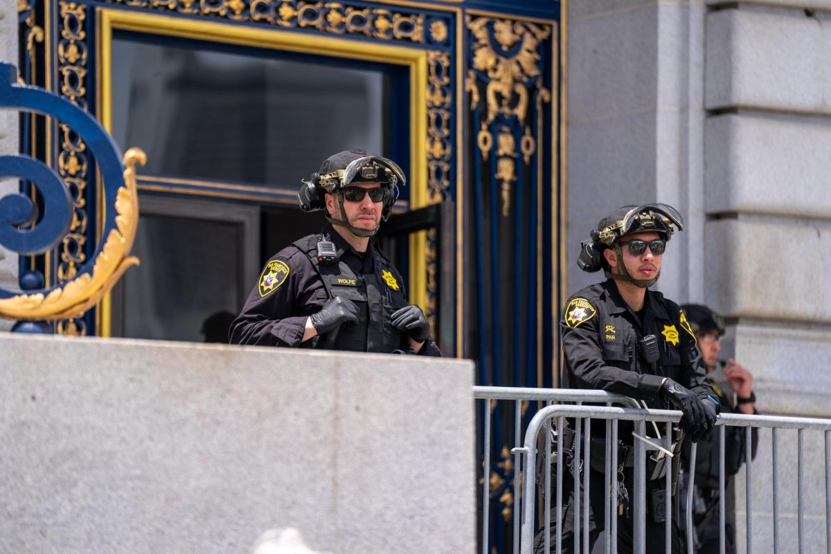 San Francisco Sheriff Officers look on at the "No Kings Day" protest from the top steps of the Civic Center Plaza steps on Saturday, June 14, 2025 in San Francisco.