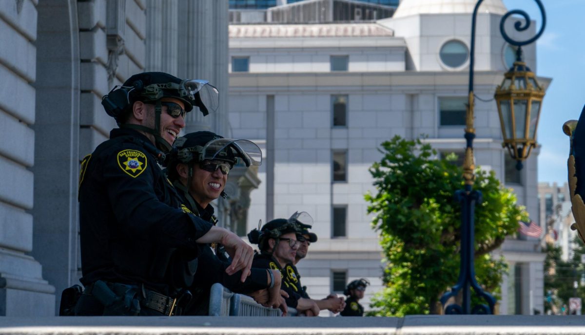 San Francisco Sheriff Officers look on at the "No Kings Day" protest from the top steps of the Civic Center Plaza steps on Saturday, June 14, 2025 in San Francisco.