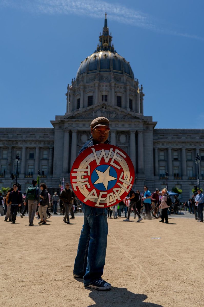 A protestor modifies a Captain America shield with "We The People" at "No Kings Day" on Saturday, June 14, 2025 in San Francisco.