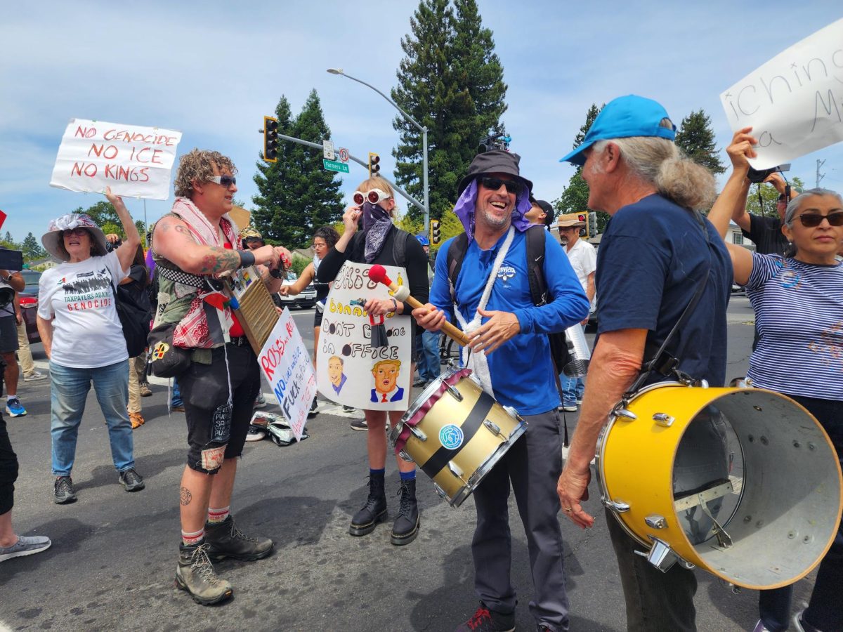 Drummers at the front of the No Kings No Clowns protest take a brief pause at a red light at the intersection of Farmers Lane and Sonoma Avenue.