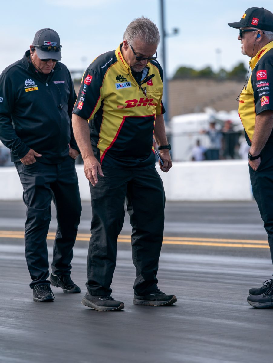 Crew members from DHL take a look at the drag strip prior to the run on day one of the DENSO NHRA Sonoma Nationals on Friday, July 25, 2025 in Sonoma.