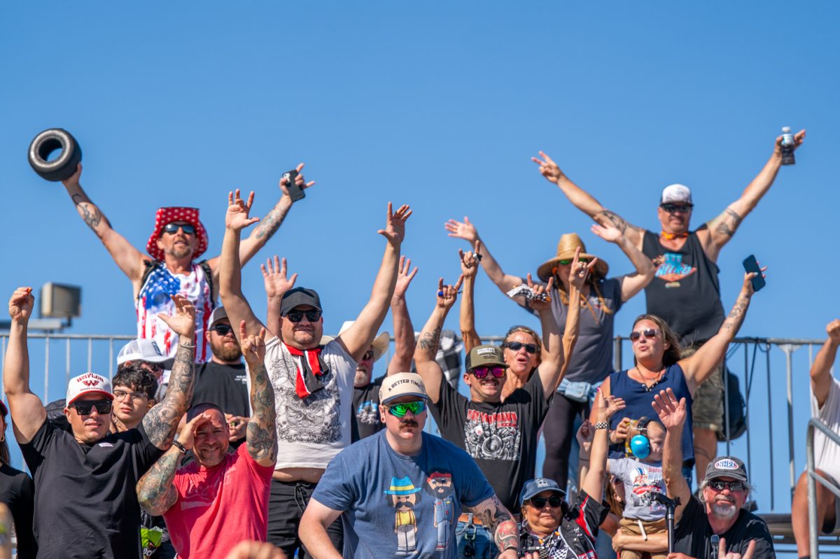 Spectators hold their arms out for NHRA swag during the track delay on day two of the DENSO NHRA Sonoma Nationals on Saturday, July 26, 2025 in Sonoma.