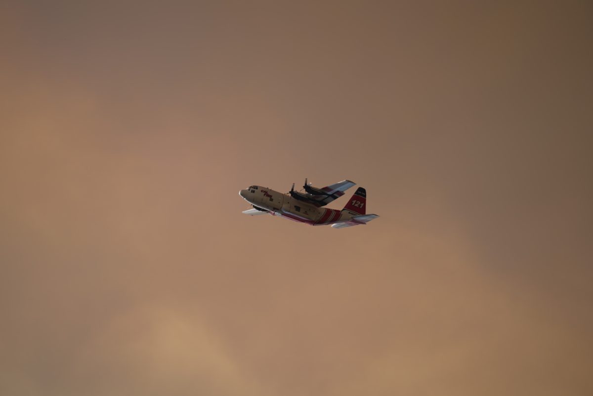 A Cal Fire S-2T air tanker flies over the Pickett Fire north of Calistoga Thursday evening, Aug. 21, 2025.