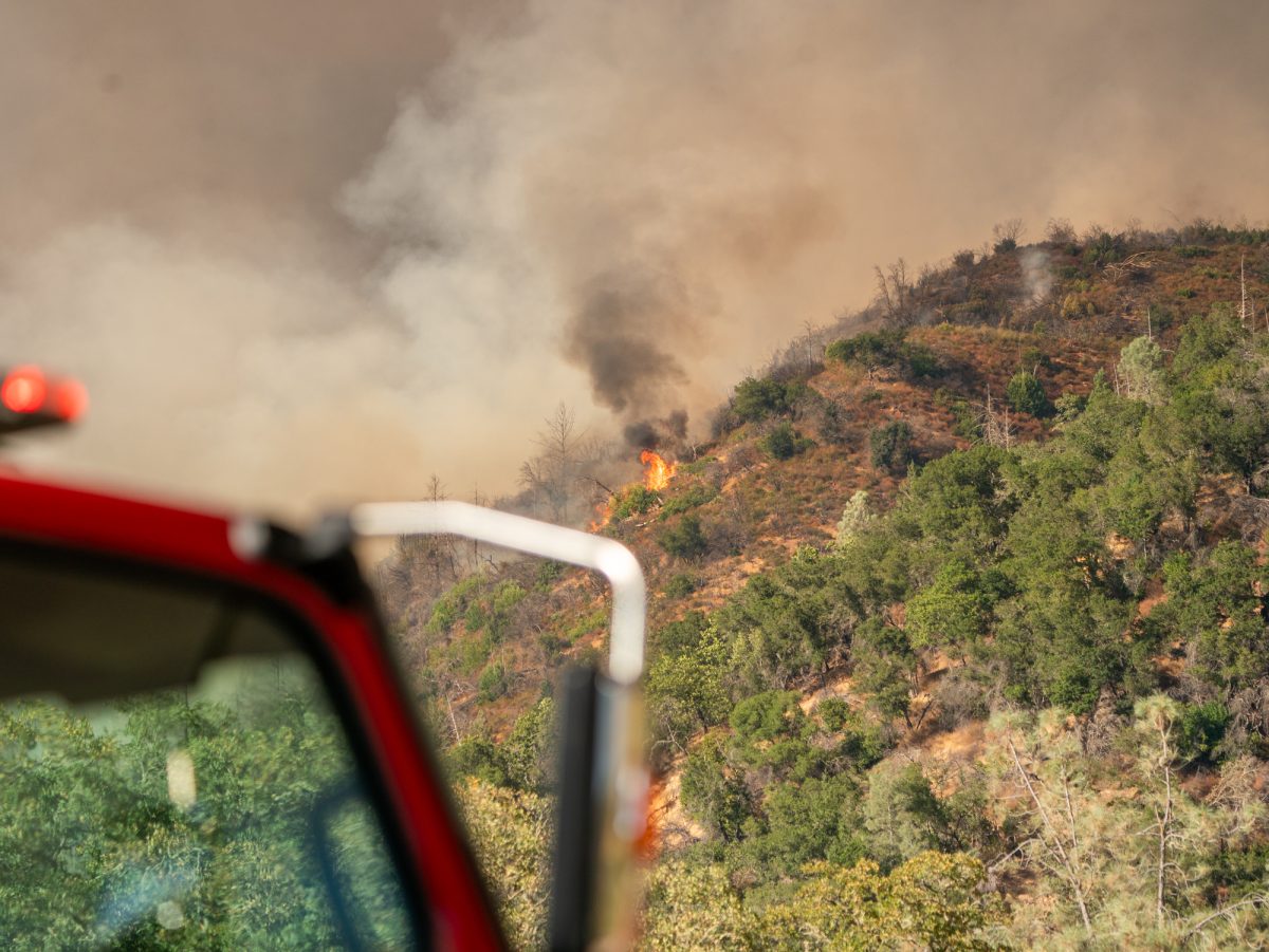 Flames crest the hillside above Cal Fire's base camp on Pickett Road near Calistoga as authorities issue evacuation warnings and orders on Thursday, Aug. 21, 2025.