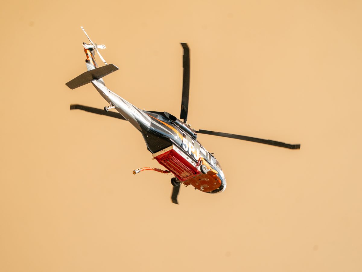 A Cal Fire contract helicopter, 5PJ, capable of carrying up to 1,100 gallons of water approaches the Pickett Fire near Calistoga, Calif. on Thursday, Aug. 21, 2025.