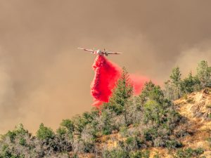 A Cal Fire air tanker drops fire retardant on the burning hills above Pickett Road near Calistoga, Calif. on Thursday, Aug. 21, 2025.