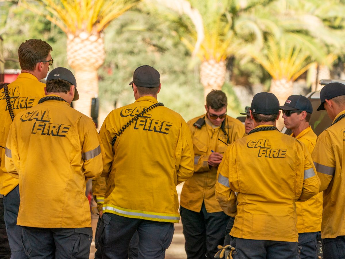 Cal Fire crew members strategize their approach for the Pickett Fire at the base camp set up on Pickett Road near Calistoga, Calif. on Thursday, Aug. 21, 2025.
