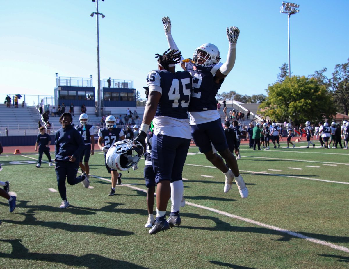 From left to right, defensive backs Brandon Williams and Dexter Trevers celebrate midfield after taking the win against Laney College on Saturday, Sept. 27 at home.