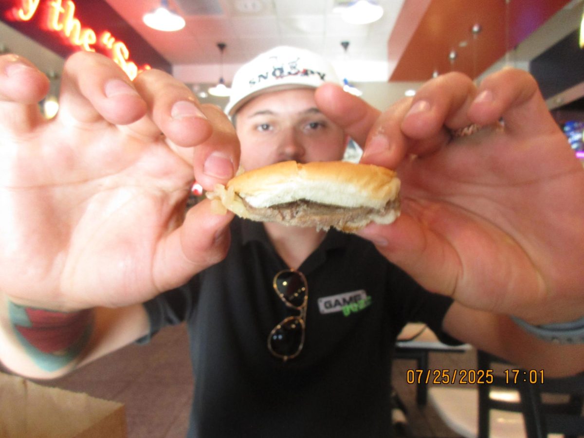 Videographer Falco Zimmerman showcases the rubbery compression capabilities of a White Castle Original Slider at 5:01 p.m. July 25 at the White Castle in Las Vegas, Nevada.