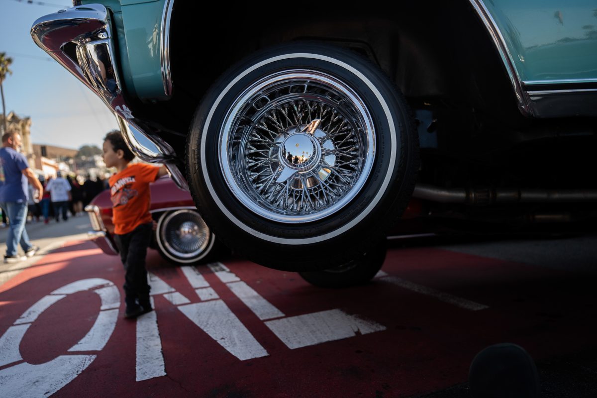 A lowrider raised with hydraulic suspension sits on Mission Street, during the King of the Streets lowrider parade in San Francisco on Saturday, Sept. 20, 2025. As the name implies, low-riders cruise low to the ground, but creators commonly incorporate hydraulic suspension systems that allow the car to sit on three wheels.