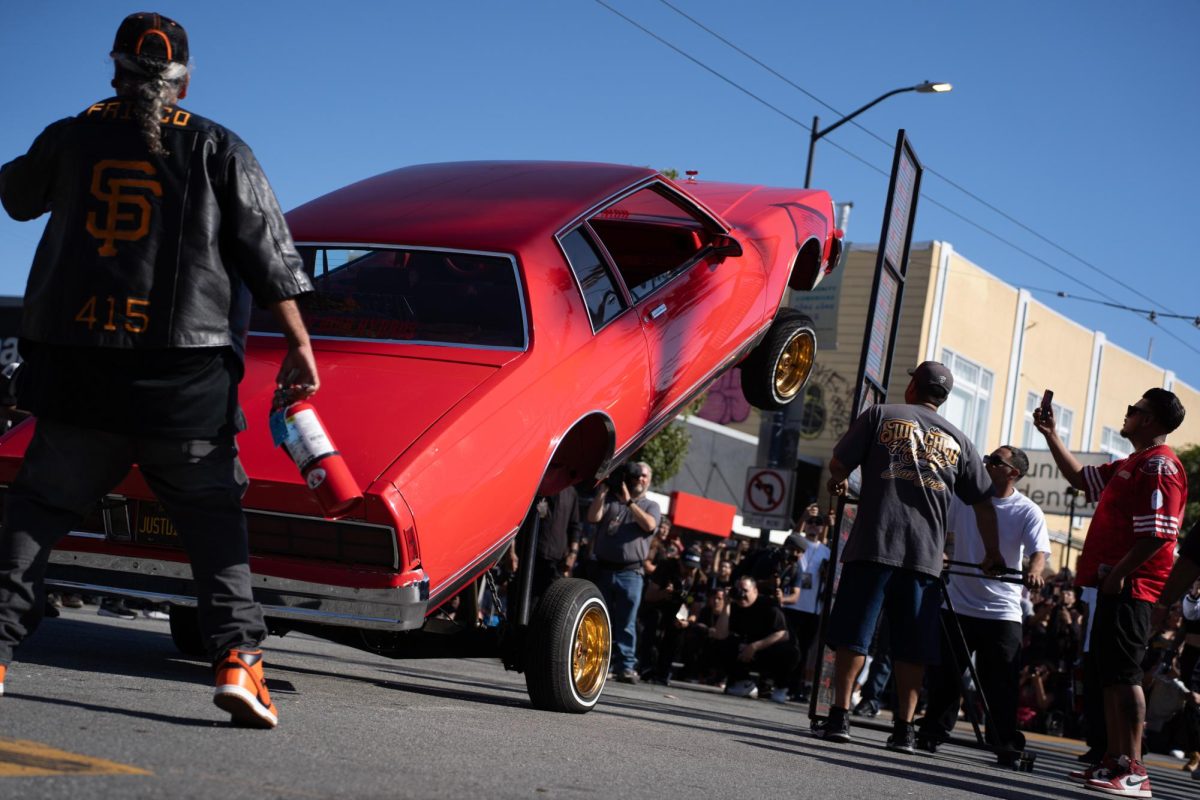 Safety and staff members watch as a car bounces for the Thrill of the Hop competition, during the King of the Streets lowrider parade on 24th and Mission Street in San Francisco on Saturday, Sept. 20, 2025.