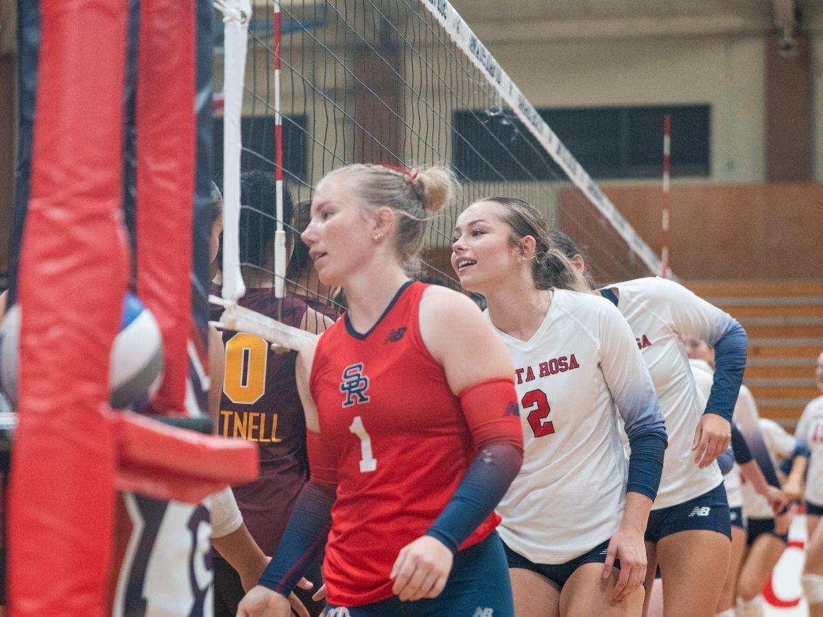 From left to right, sophomore defensive specialists Amber Smart and Jasmine Forster meet Hartnell College at the net prior to the matches in Haehl Pavilion on Wednesday, Sept. 10.