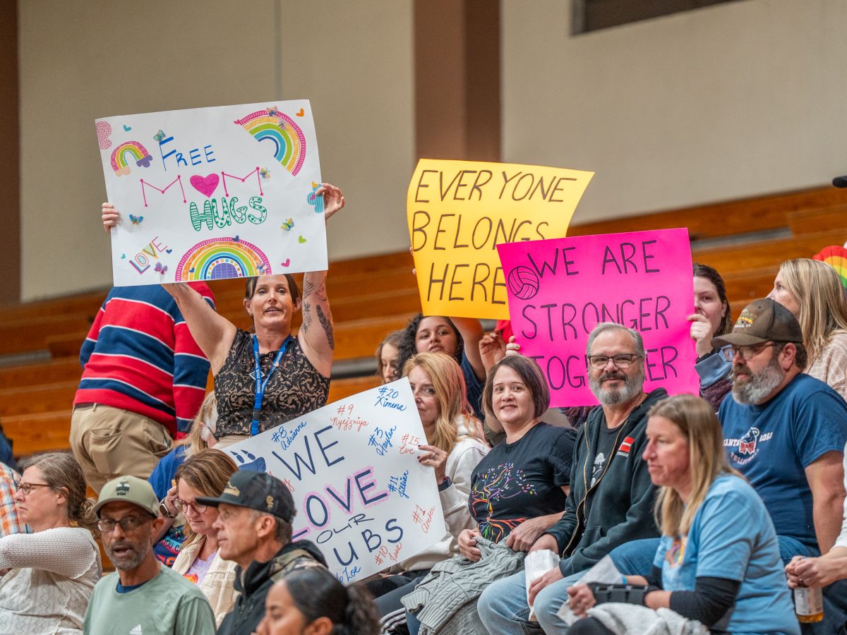 Community members hold signs in support of a trans athlete on the SRJC women's volleyball team inside Haehl Pavilion on Wednesday, Oct. 8.