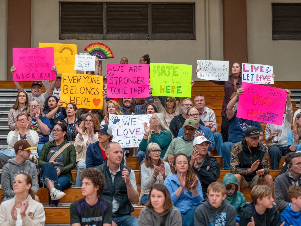 Community members hold signs in support of a trans athlete on the SRJC women's volleyball team inside Haehl Pavilion on Wednesday, Oct. 8.