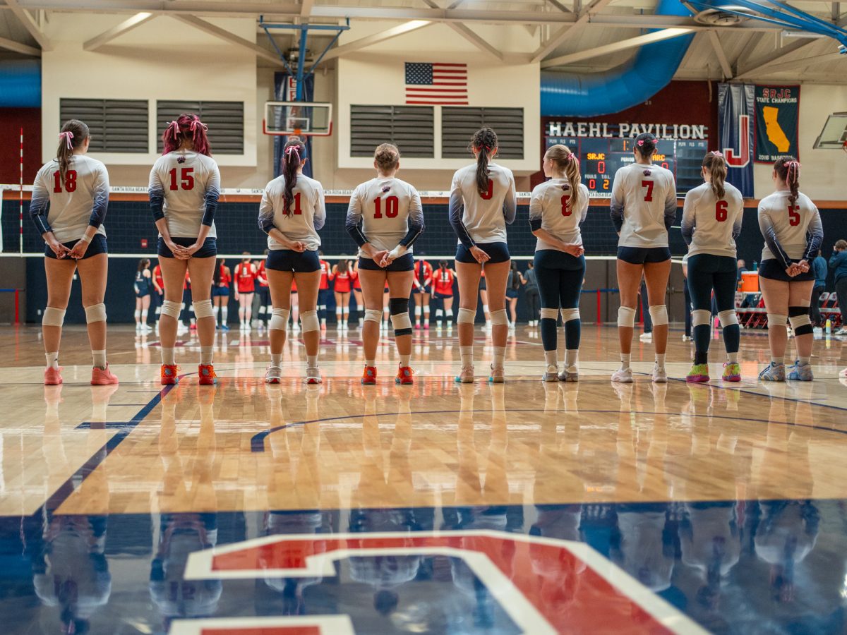 Members of the SRJC women's volleyball team stand for the national anthem ahead of the game against American River College on Wednesday, Oct. 8 in Haehl Pavilion.