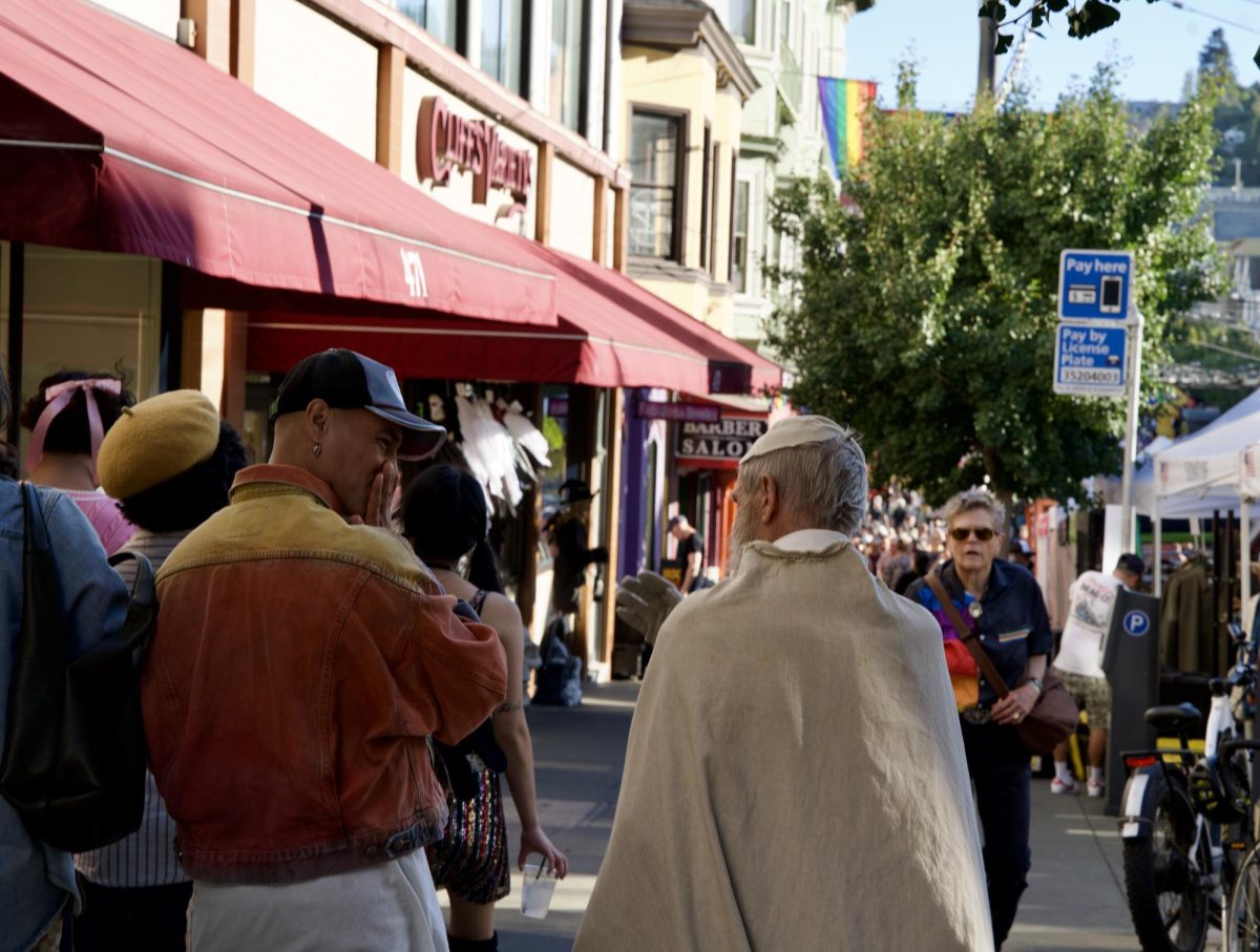 A Castro Street Fair attendee giggles while conversing with a person dressed as a priest on Sunday Oct. 5, 2025. 