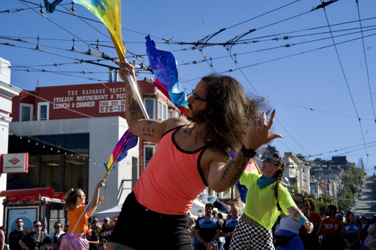 A member of the Harvey Milk Pride Colorguard shows off their manicured nails as they flip their hair (and flag) during one of the group’s performances at the Castro Street Fair on Sunday Oct. 5, 2025. 