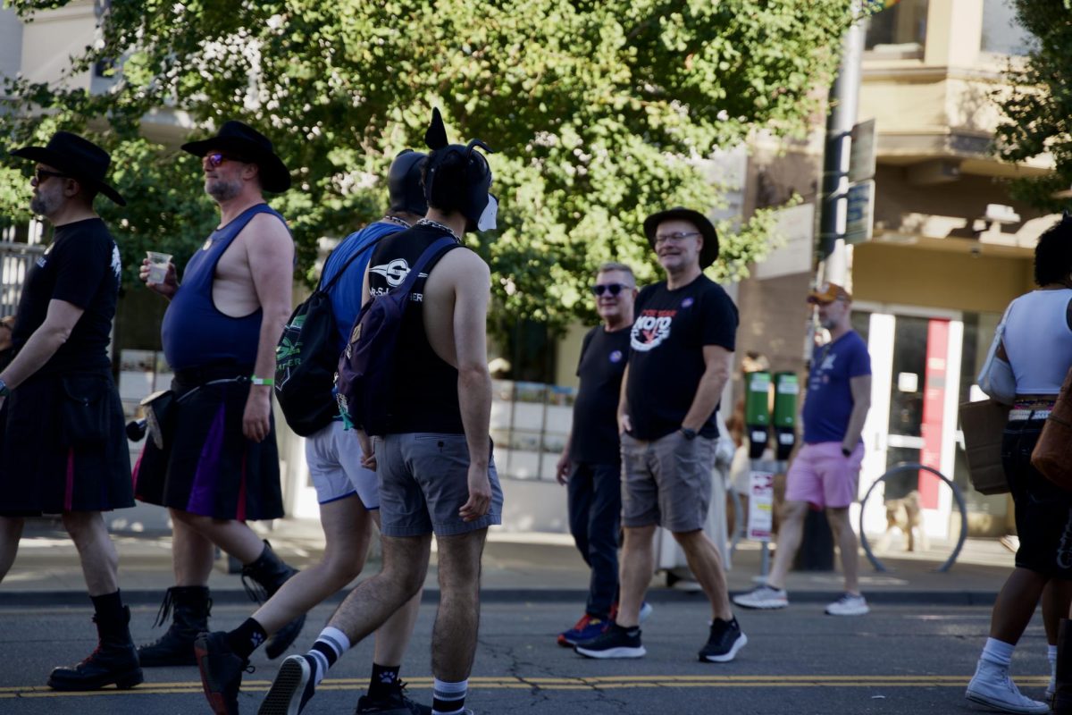 Castro Street Fair attendees smile at one of the many open expressions of identity welcomed at and embraced by the event and the broader neighborhood’s community on Sunday Oct. 5, 2025. 