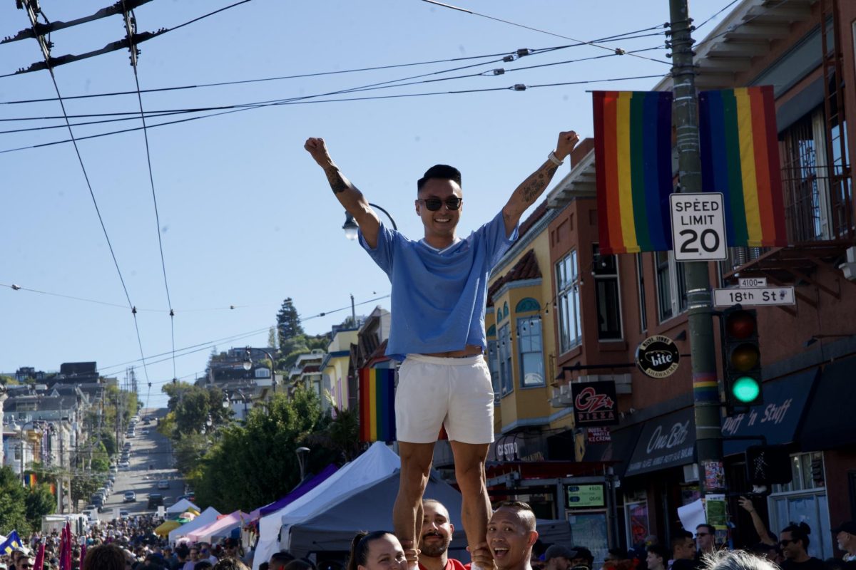 SF Cheer cheerleaders practice a pose with a Castro Street Fair attendee after holding one of their many interactive games on Sunday Oct. 5, 2025. 