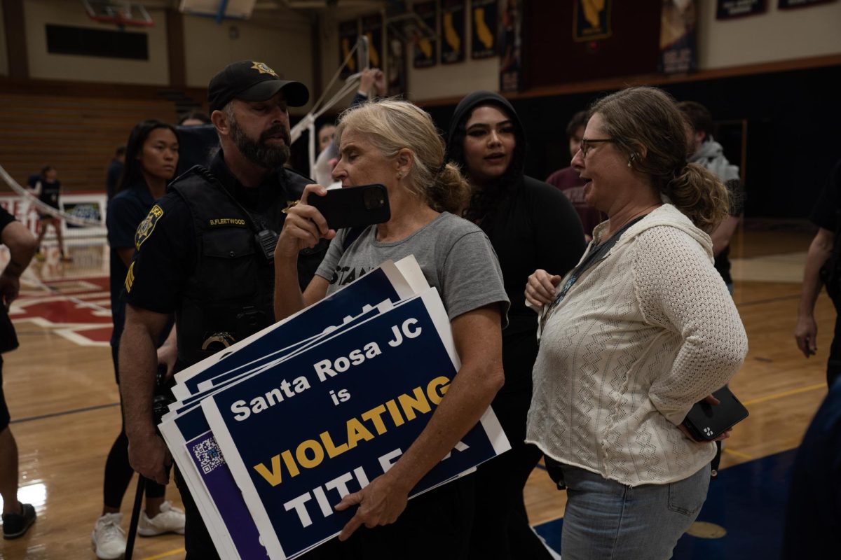 Police usher Beth Bourne and other anti-transgender demonstrators out after the SRJC women’s volleyball game on Wednesday, Oct. 8 in Haehl Pavilion.
