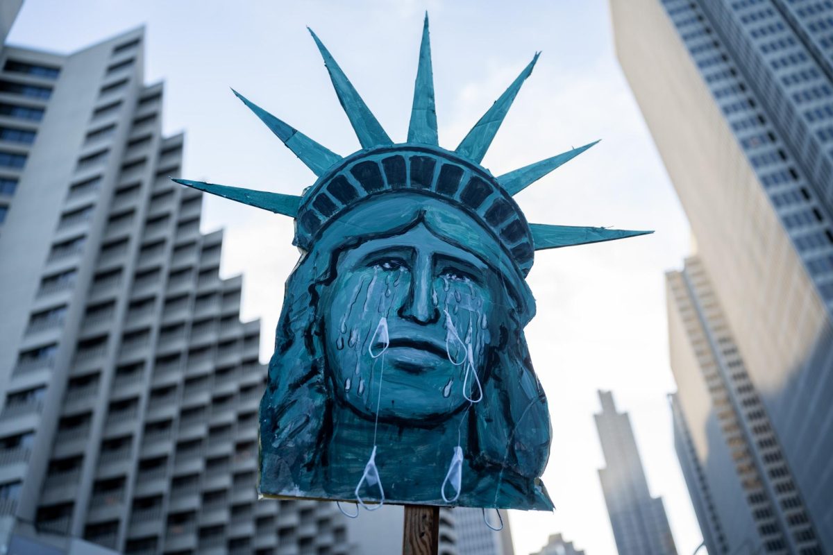 A demonstrator holds a sign that depicts a crying Statue of Liberty, a symbol of freedom to immigrants in America, on Thursday, Oct. 23 in San Francisco, Calif. 
