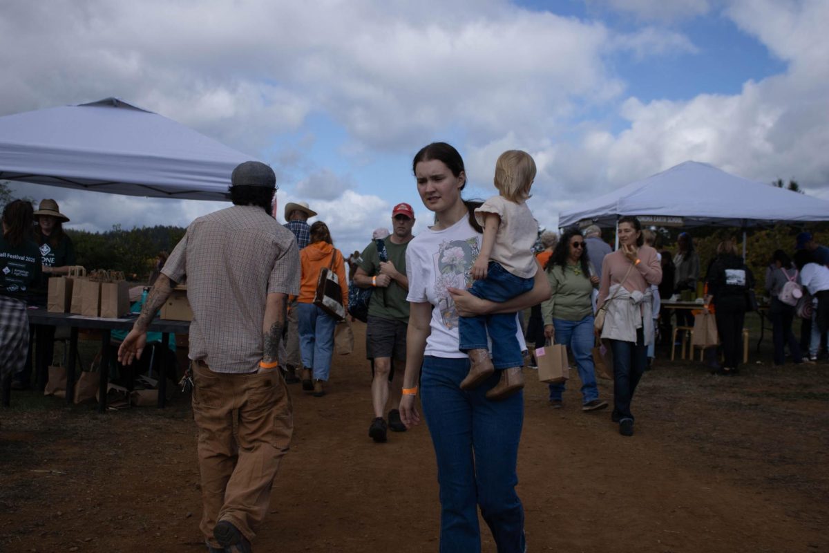A woman with her child walking from the You Pick Pumpkin Patch to other areas of the farm Saturday, Oct. 12 at Shone Farm.