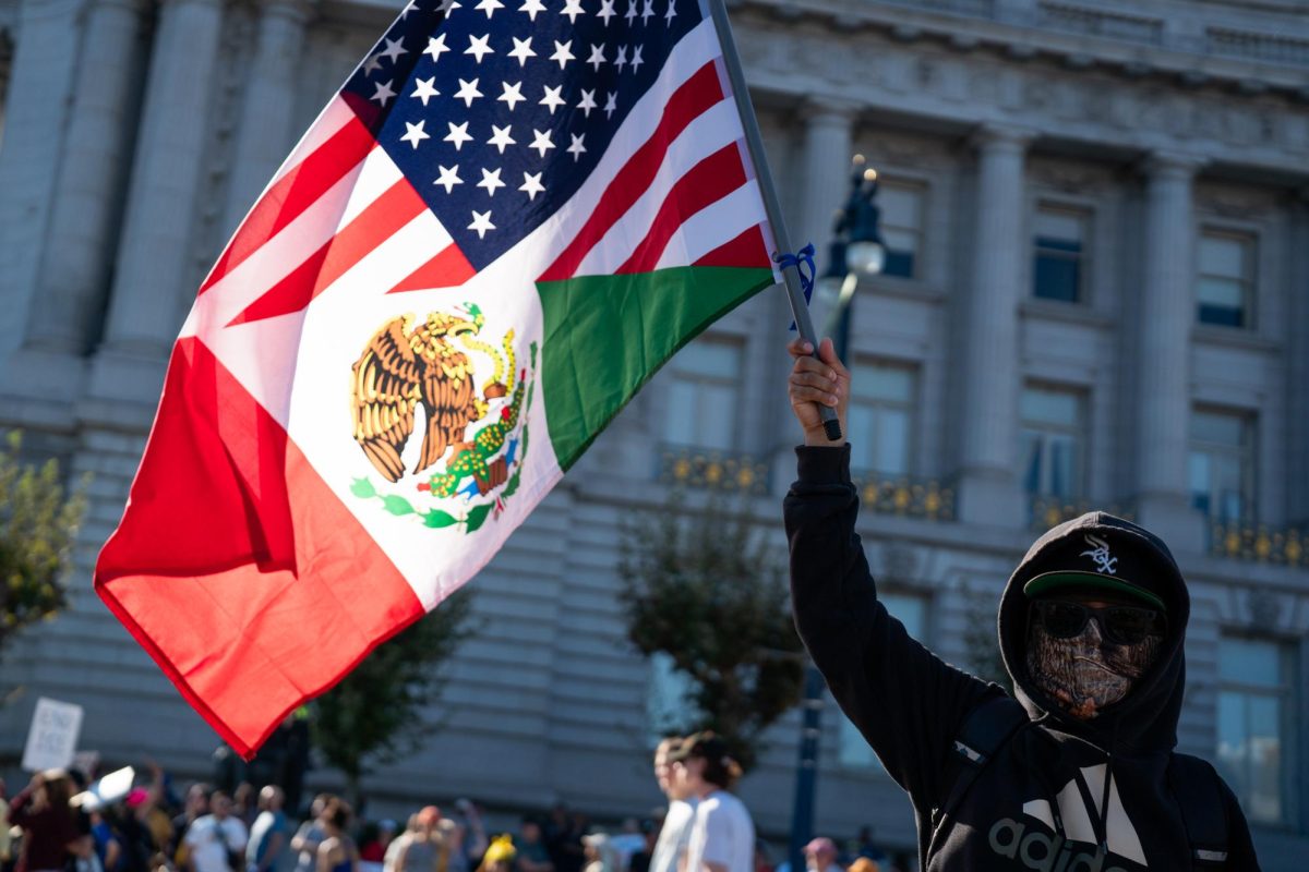 A protestor waves around a split flag representing both the U.S. and Mexico in front of San Francisco City Hall Saturday, Oct. 19. 