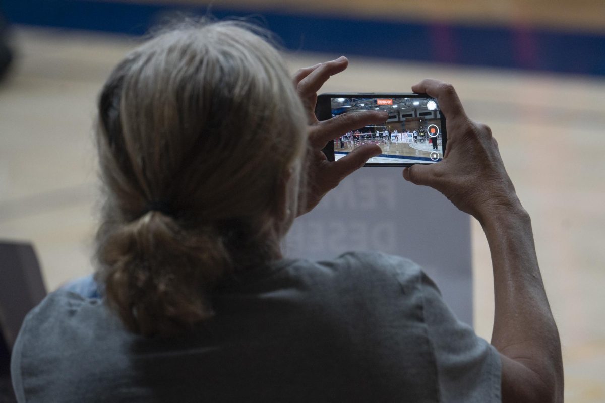 Beth Bourne, Chair of Yolo County's chapter of Moms for Liberty, zooms in while recording SRJC women's volleyball players Wednesday, Oct. 8, 2025 in Haehl Pavillion.