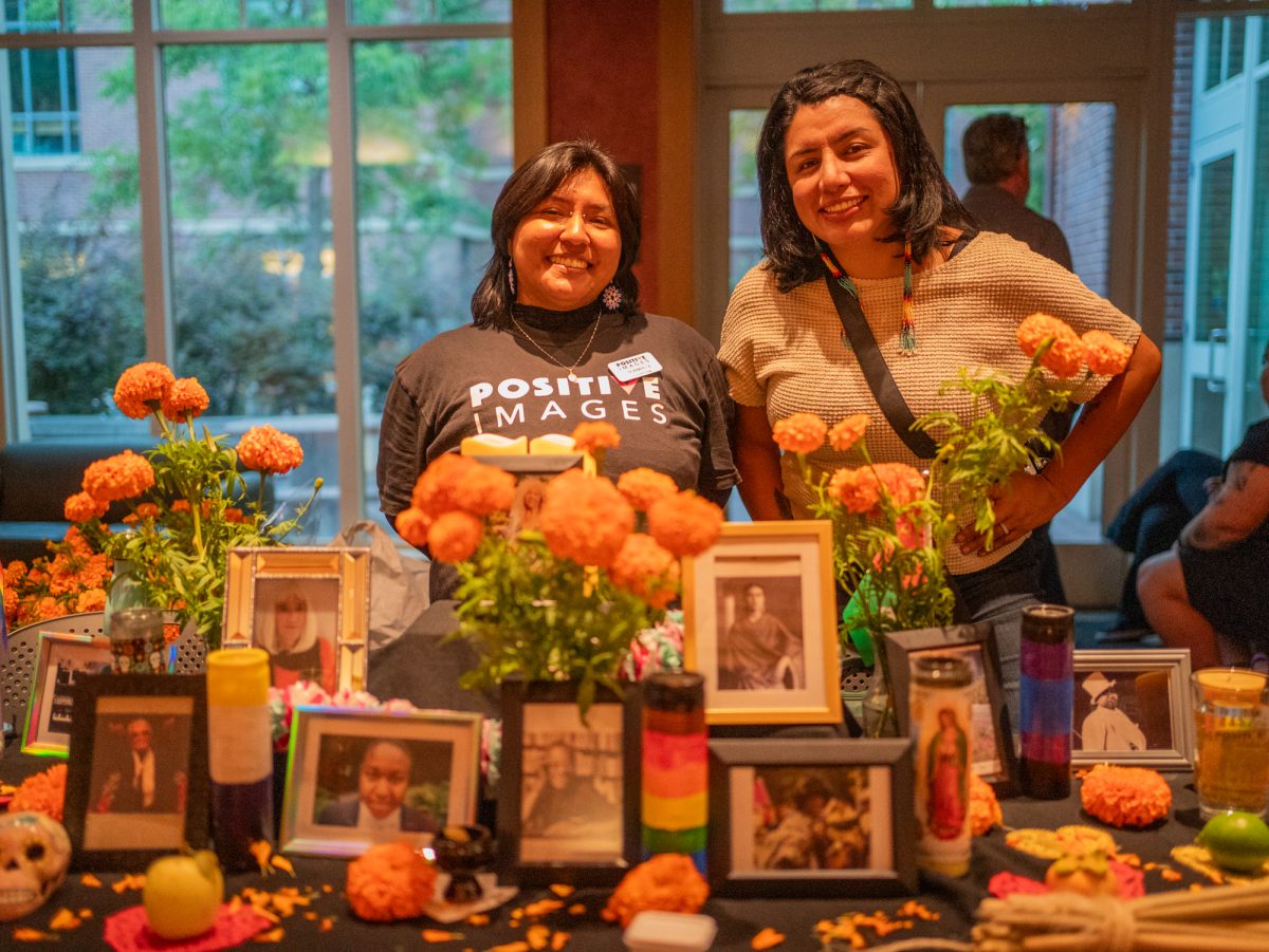 From left to right, Ronimar and Laura finish up the final touches of the Positive Images ofrenda for the SRJC Dia de los Muertos celebration in Bertolini Hall on Tuesday, Oct. 21.