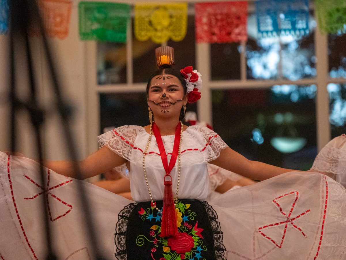 A member of Espejo de mi Alma faces towards the audience during the group's opening dance for the SRJC Dia de los Muertos celebration in Bertolini Hall on Tuesday, Oct. 21.
