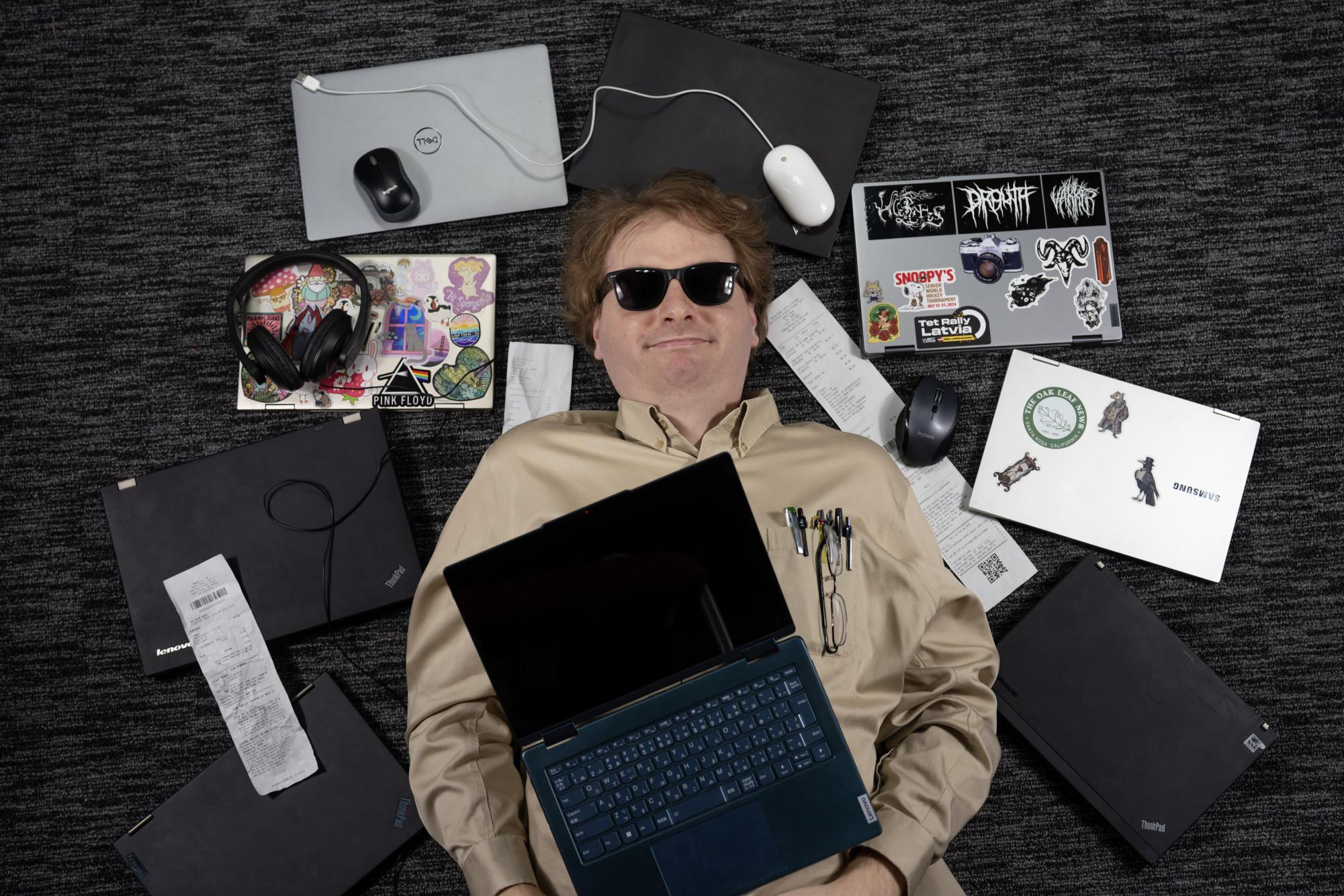 Benjamin Lyle rests in a graveyard of defunct laptops. He hopes this guide will help prevent other students' used laptop purchase tragedies.