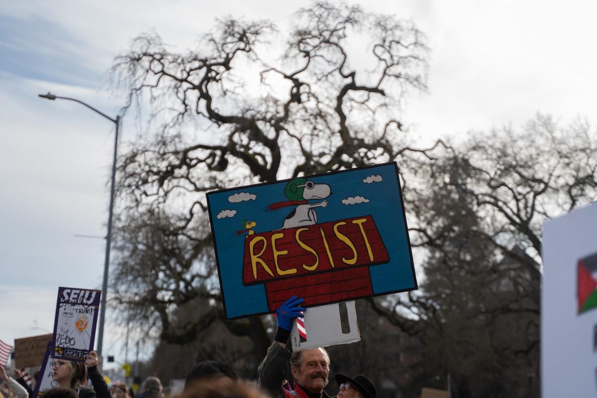 A protestor marches through the "Peanuts" creator's hometown holding a sign with the comic's most well-known character at the Free America Walkout on Mendocino Avenue in front of Santa Rosa Junior College Jan. 20, 2026.  