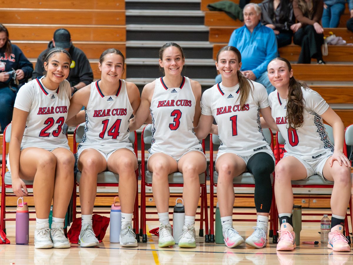 From left to right, freshman forward Jordan Washington, sophomore forward Kaia Eubanks, sophomore guard Abigail Tacla, freshman guard Elle Picard and sophomore guard Caitlin Baldwin sit at the sidelines waiting for lineup to be read before their game against Diablo Valley College on Friday, Jan. 30 at home.