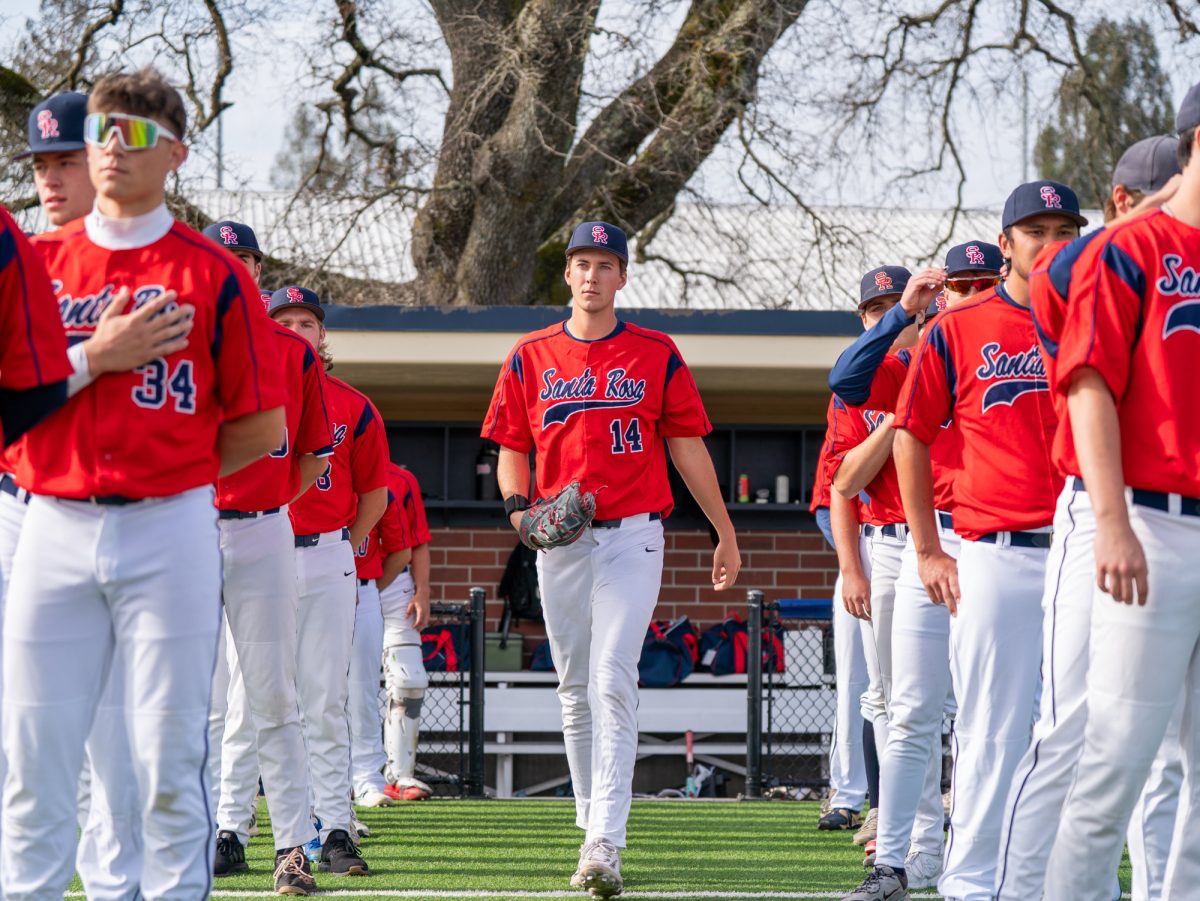 Sophomore starting pitcher Lucas Hermes walks out to the mound from the dugout for the game against College of Marin on Saturday, Jan. 31 at home.