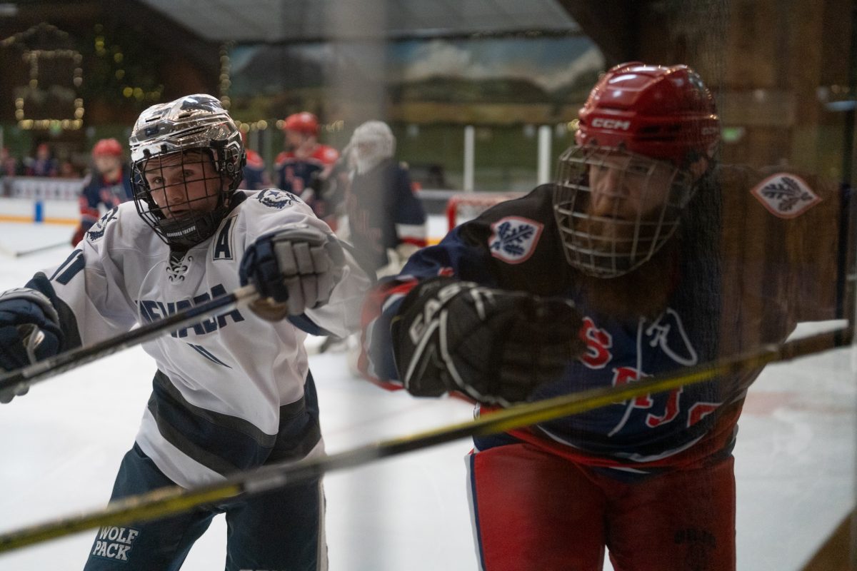 Wolfpack forward Christopher Lai attempts to keep control of the puck as Polar Bear defenseman and winger Jon Christenson charges towards him Friday, Feb. 6 at Snoopy's Home Ice.