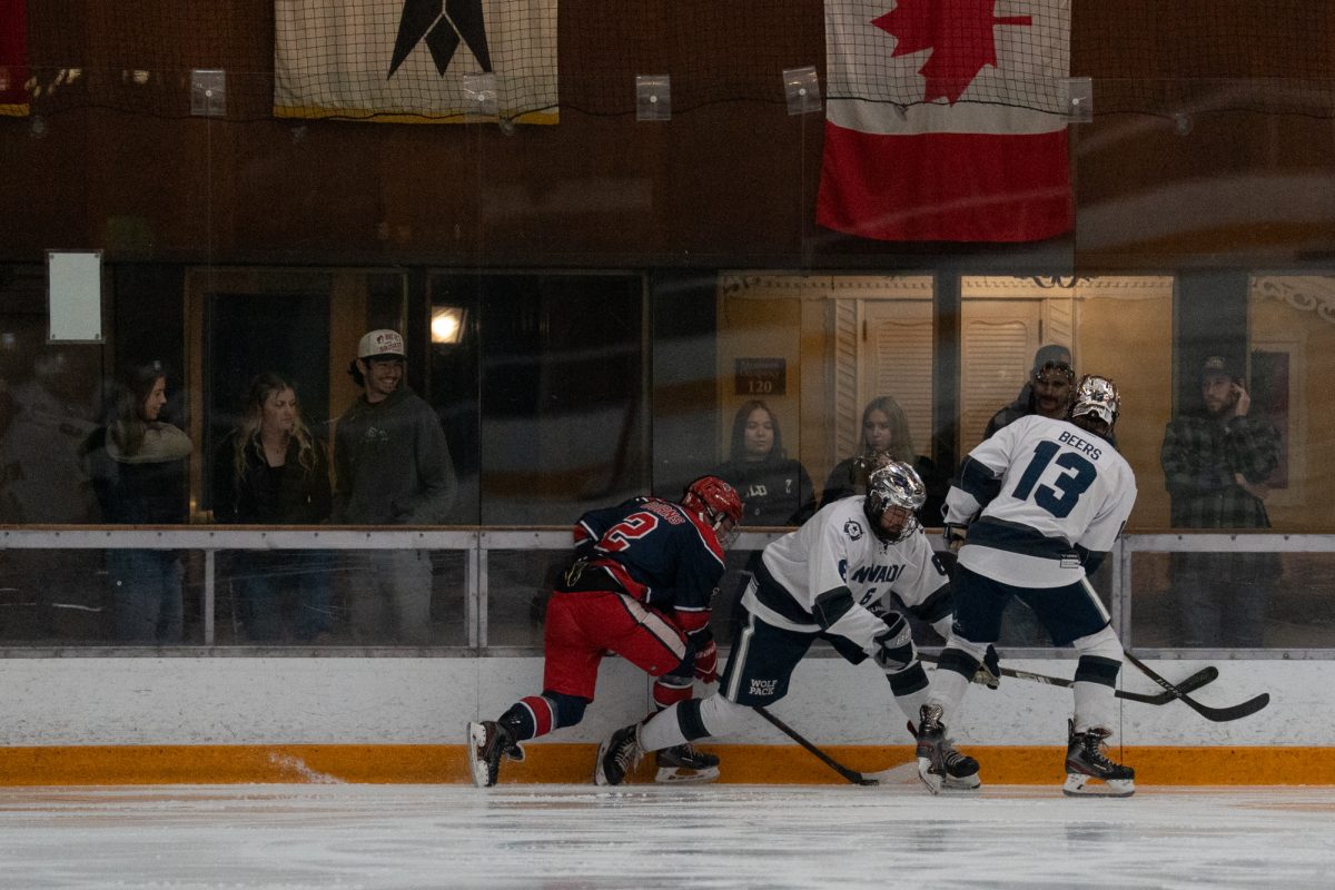 Spectators watch as Polar Bear center and winger Traber Burns attempts to free the puck from two Wolfpack players Friday, Feb. 6 at Snoopy's Home Ice.