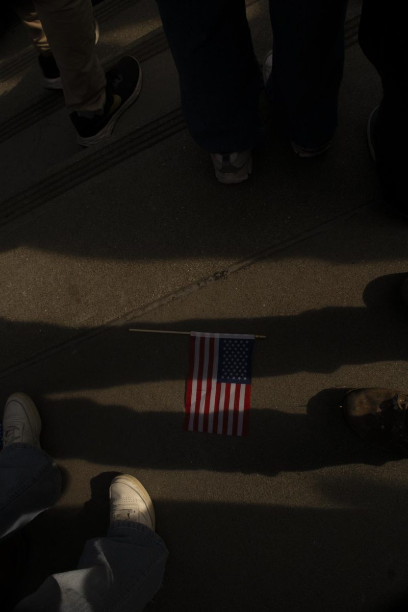 An American flag lies on the floor while protestors chant around it during the ICE Out protest at Dolores Park Friday, Jan. 30, 2026.