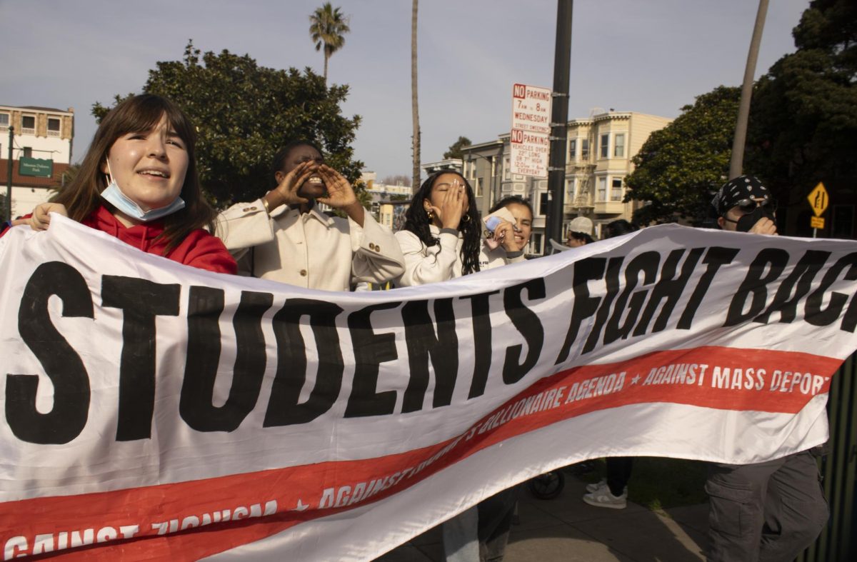Students hold a banner while chanting and marching into Dolores Park during the ICE Out protest Friday, Jan. 30, 2026.