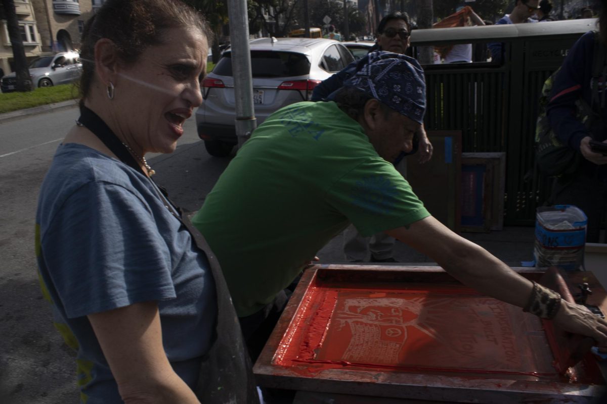 Drew School art teacher Ali Blum with her husband, Calisto, screen printing signs for the ICE out protest at Dolores Park Friday, Jan. 30, 2026.
