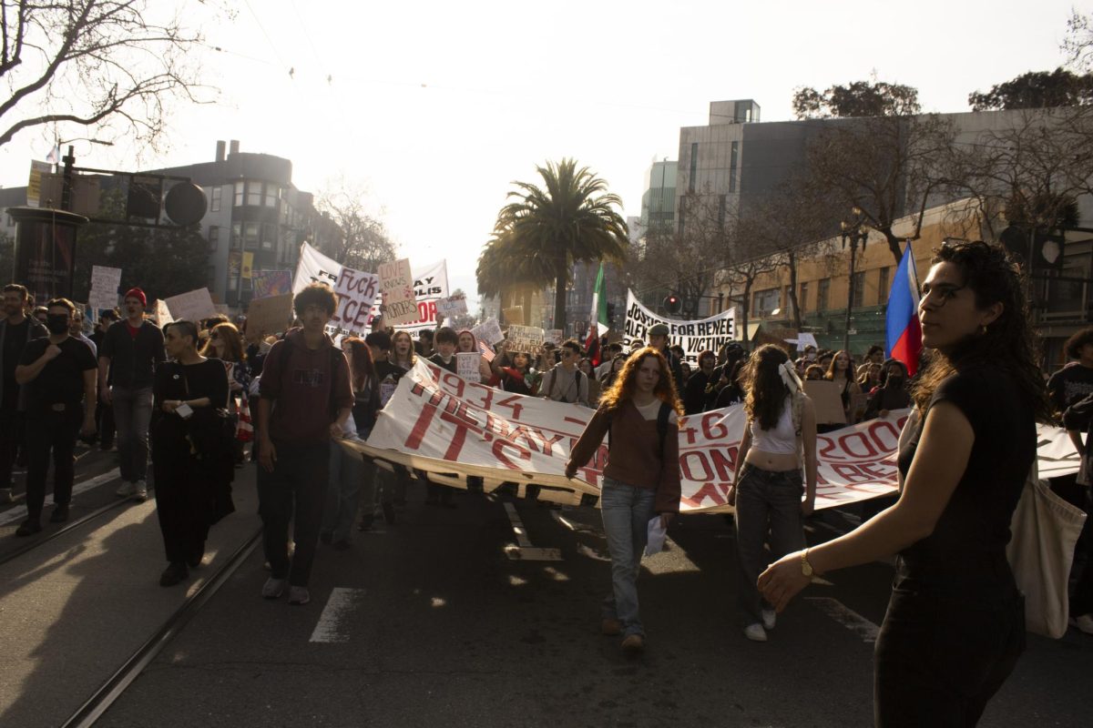 Protesters march to San Francisco City Hall holding a banner during the ICE Out march on Market Street Friday, Jan. 30, 2026.