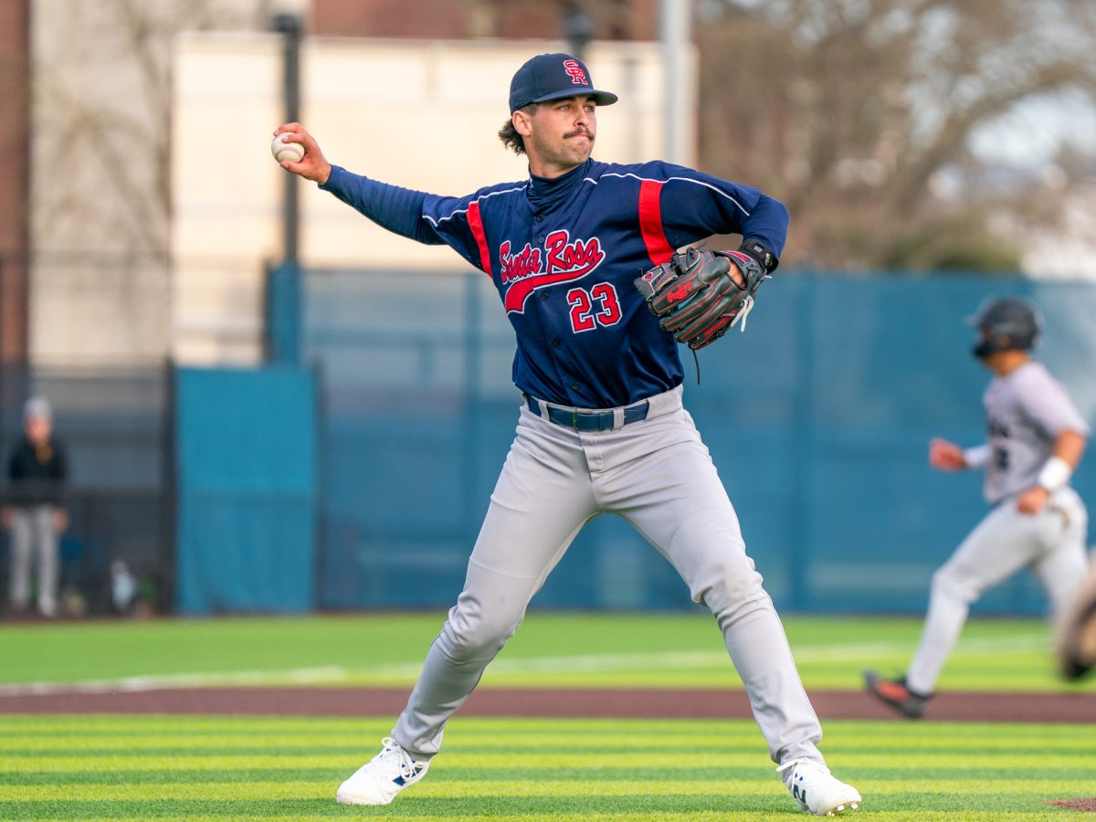 Freshman Cody Collins fields a ground ball hit to the pitcher and winds back to throw it to first base to throw the runner out in the game against Chabot on Friday, Feb. 13 at home.