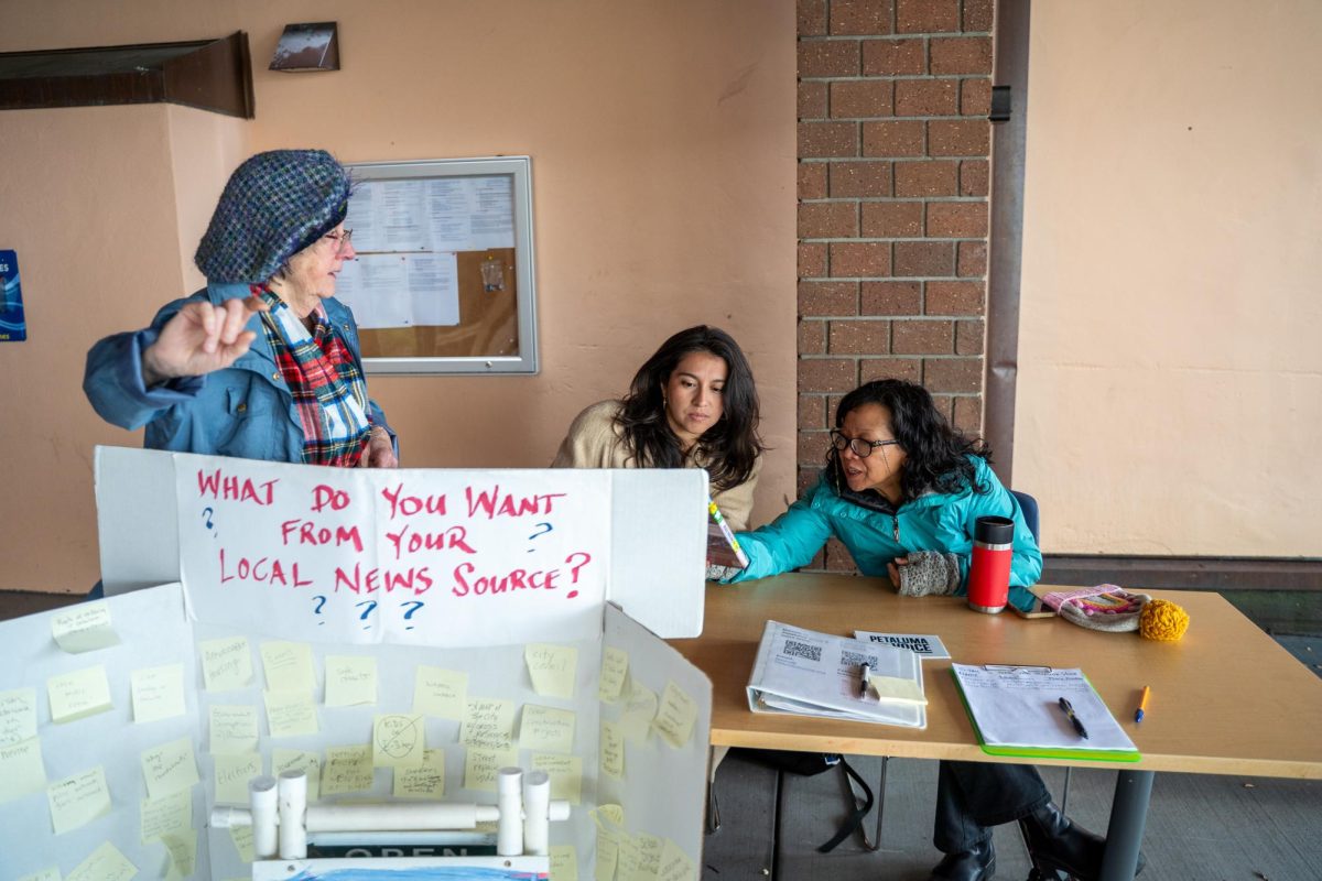 A Petaluma resident recommends a journalism movie to Jennifer Sawhney (left) and Crissy Pascual (right) Feb. 11 outside the Petaluma Regional Library.