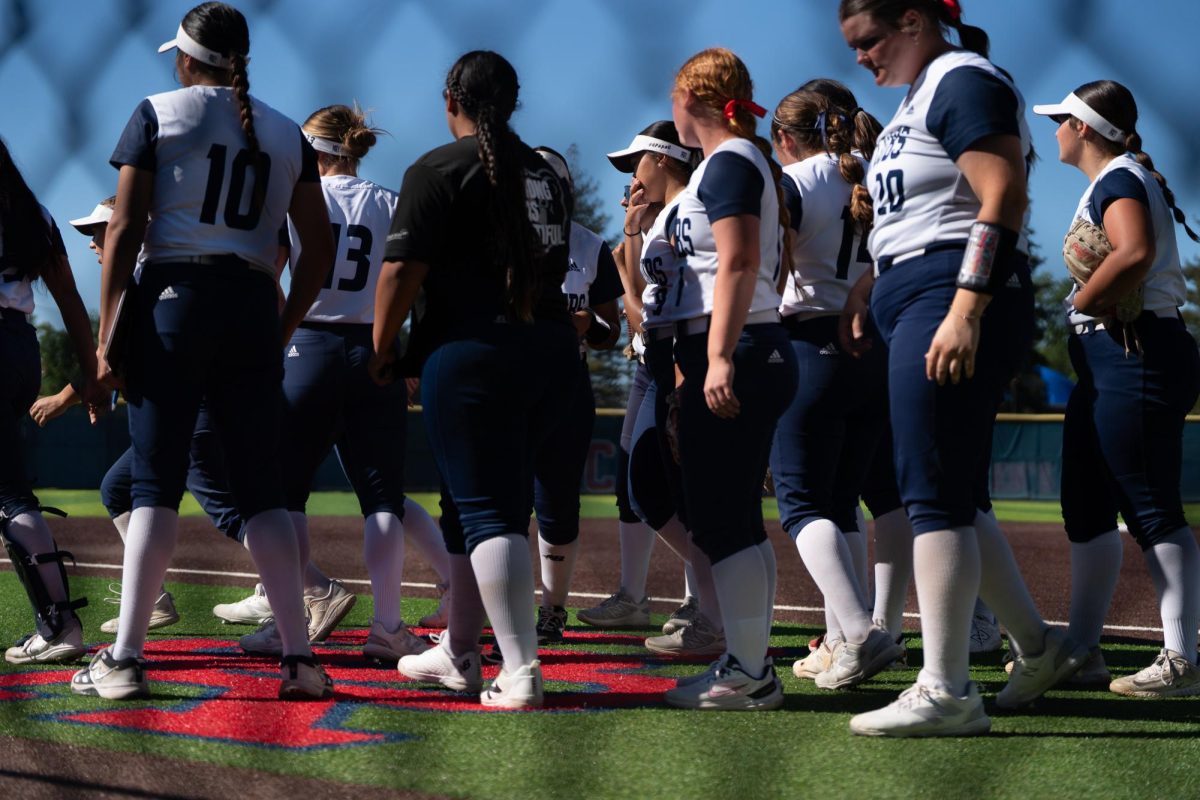 The SRJC softball team huddle together right outside of the dugout during the game against Cosumnes River College at home on Tuesday, March 24, 2026.