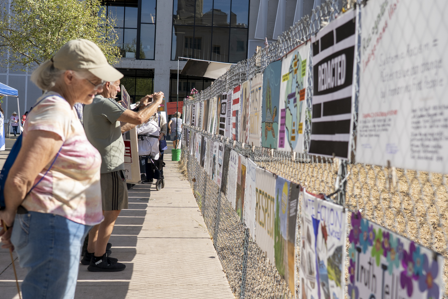 A wall of resistance signs attached to the fence surrounding the lot next to Hotel E. Many signs call for justice others are callouts for redacted elements of the Epstein files to be released at "No Kings" protest, Old Courthouse Square Santa Rosa, March 28 2026.